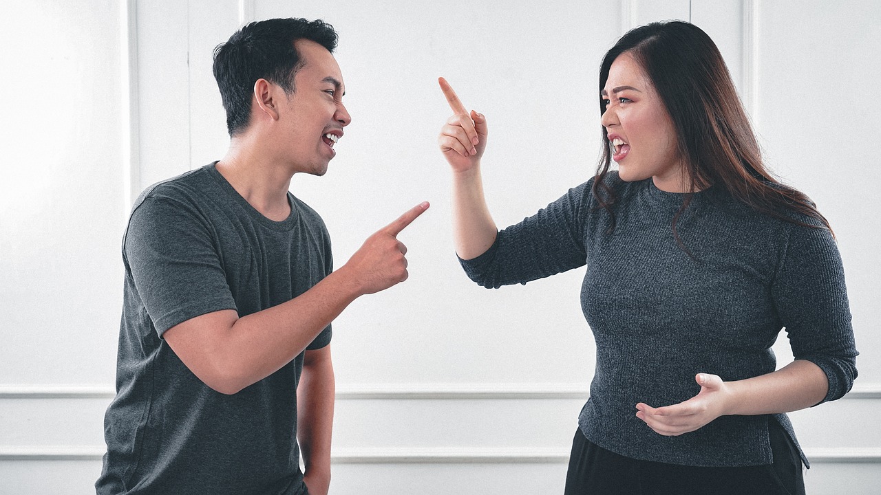 Finger pointing by husband wife at each other during argument